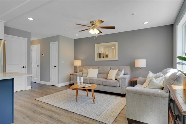 living room with light wood-style floors, baseboards, a ceiling fan, and recessed lighting