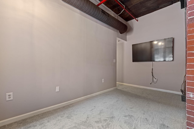 carpeted empty room featuring baseboards