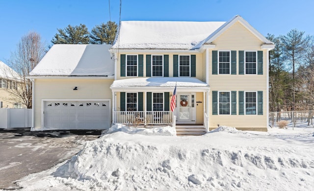 view of front of property featuring a porch, an attached garage, fence, and aphalt driveway