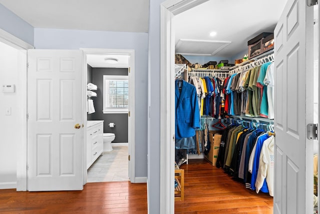 spacious closet with attic access and wood finished floors