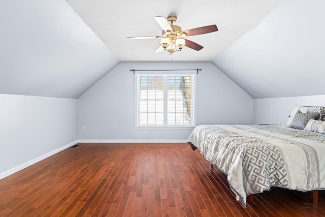 bedroom with lofted ceiling, visible vents, dark wood-type flooring, ceiling fan, and baseboards