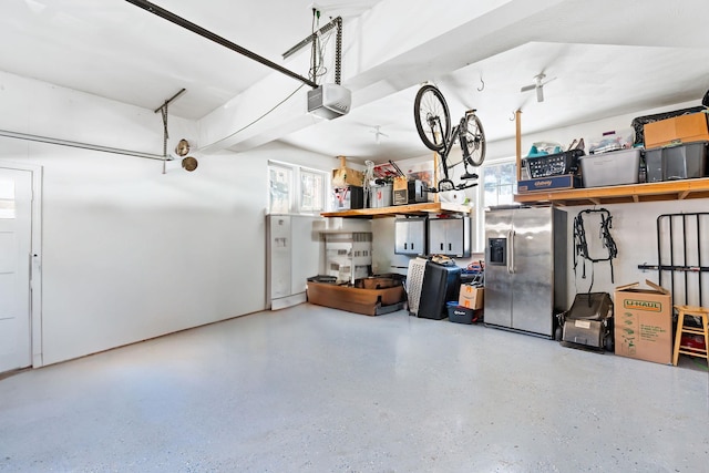 garage featuring a garage door opener and stainless steel refrigerator with ice dispenser