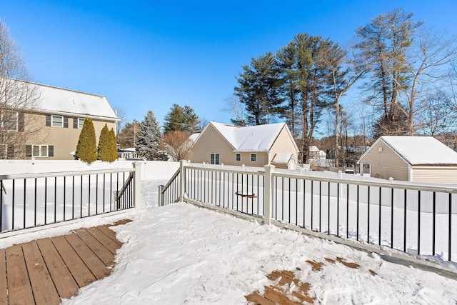 snow covered deck featuring a fenced backyard and a residential view