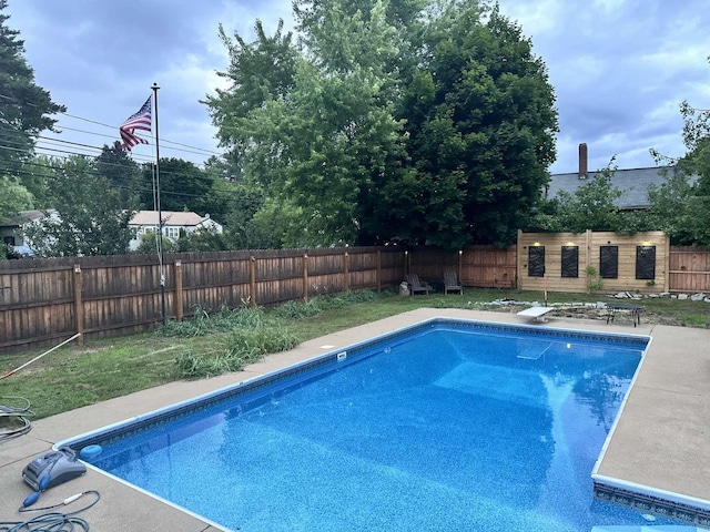 view of swimming pool with a fenced backyard and a diving board