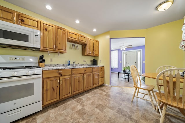 kitchen featuring baseboards, white appliances, brown cabinets, and recessed lighting