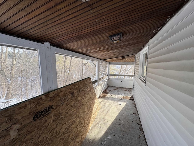 unfurnished sunroom with wood ceiling and plenty of natural light