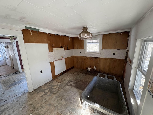 kitchen with brown cabinetry, wainscoting, and wood walls