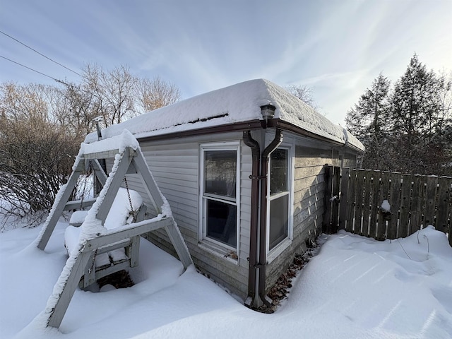 view of snowy exterior with fence