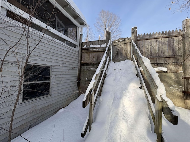 view of snow covered exterior with fence