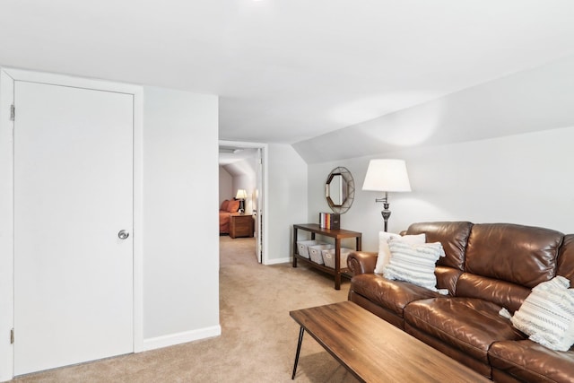 living area with lofted ceiling, light colored carpet, and baseboards