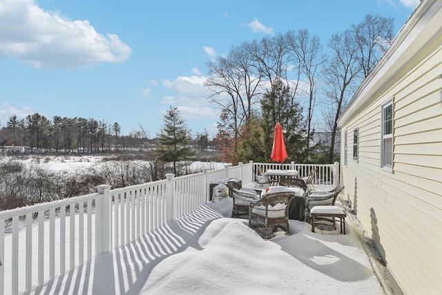 snow covered patio featuring a wooden deck