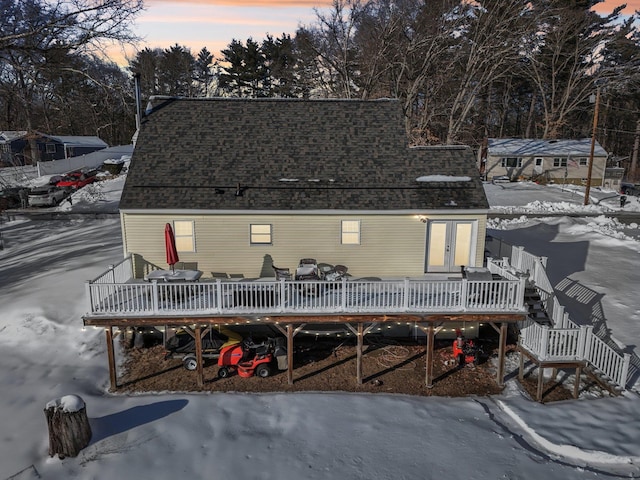 view of front of property with a deck, a shingled roof, and stairway