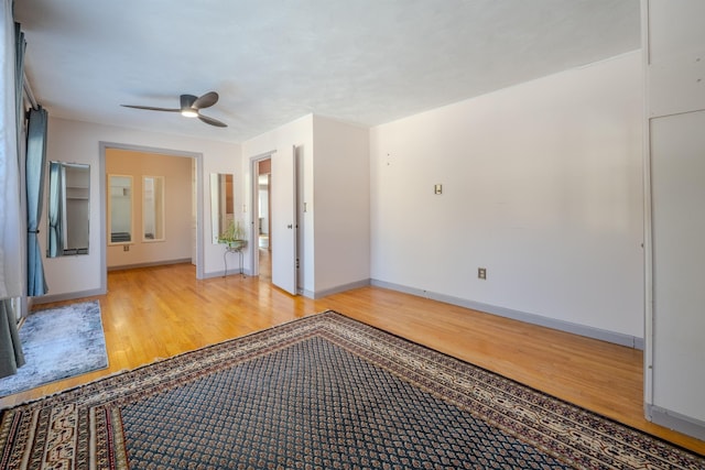 spare room with baseboards, ceiling fan, and light wood-style floors