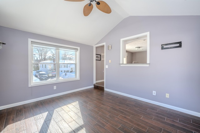 empty room with a ceiling fan, dark wood-style flooring, vaulted ceiling, and baseboards