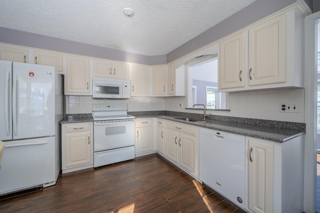 kitchen with white appliances, dark wood-type flooring, a sink, and decorative backsplash