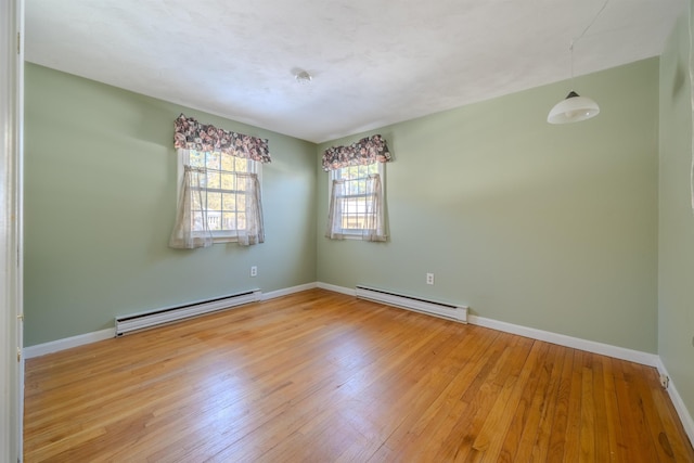 empty room with light wood-style floors, baseboards, and baseboard heating