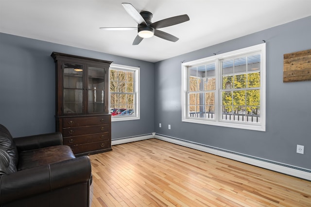 unfurnished room featuring light wood-type flooring, baseboards, baseboard heating, and a ceiling fan