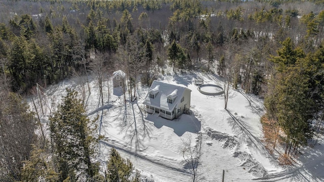 snowy aerial view featuring a forest view