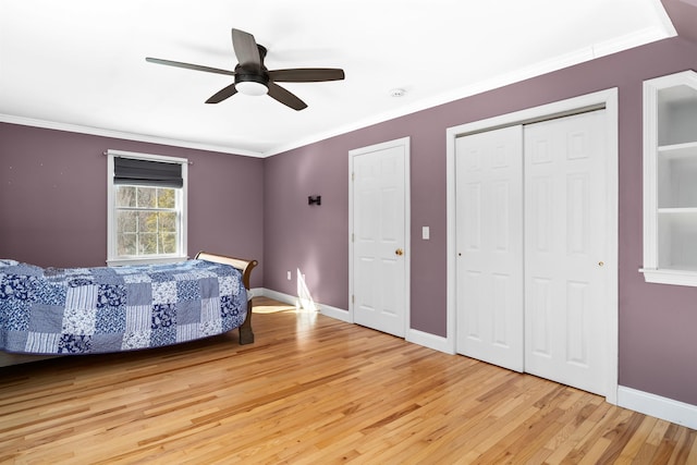 bedroom with light wood-style flooring, baseboards, and crown molding