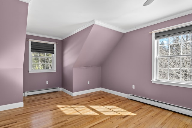 additional living space with lofted ceiling, light wood-style floors, baseboards, and baseboard heating