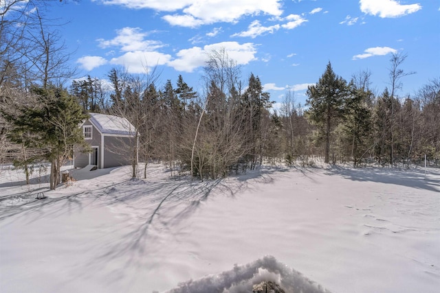 yard layered in snow featuring an attached garage