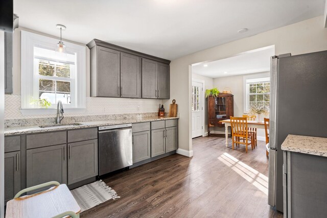 kitchen featuring a wealth of natural light, tasteful backsplash, appliances with stainless steel finishes, and a sink