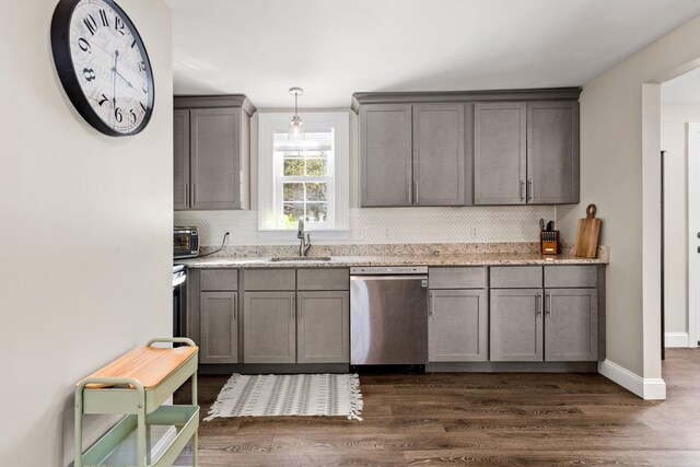 kitchen featuring decorative light fixtures, dark wood finished floors, gray cabinetry, a sink, and dishwasher