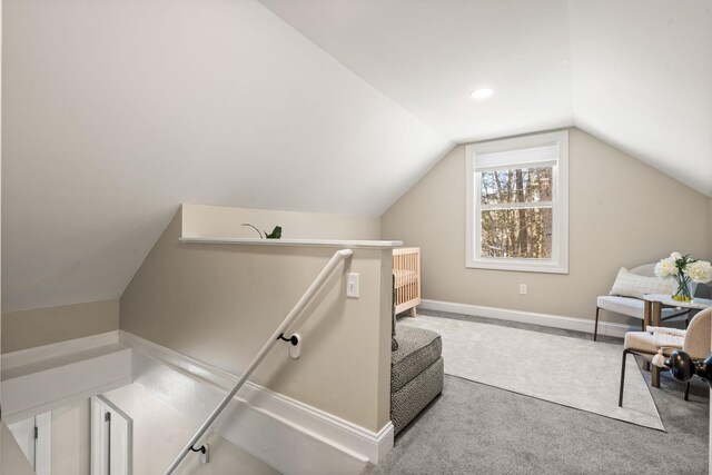 interior space featuring lofted ceiling, carpet, and baseboards