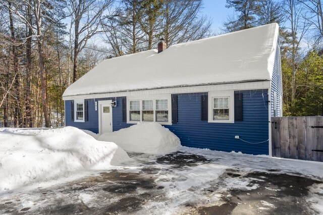 view of front of house with a chimney and fence