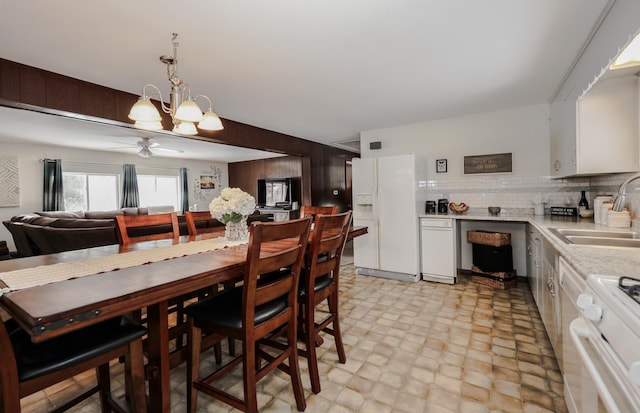 dining space with wood walls and a notable chandelier