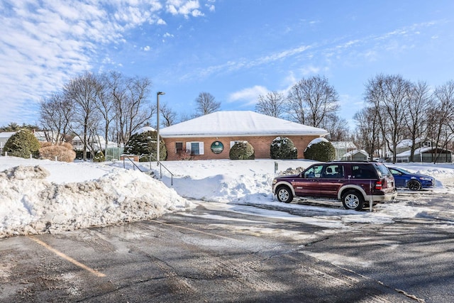 exterior space with uncovered parking and brick siding