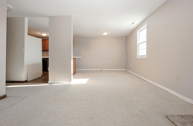 empty room featuring light carpet and baseboards