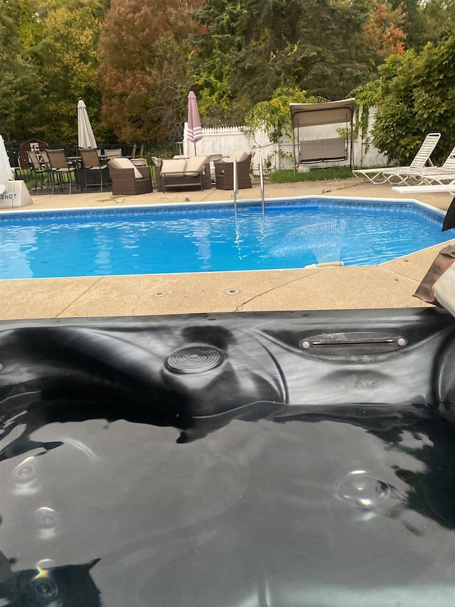 outdoor pool featuring a patio and fence