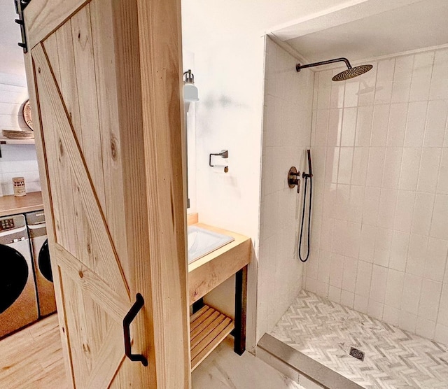 full bath featuring tiled shower and washing machine and clothes dryer