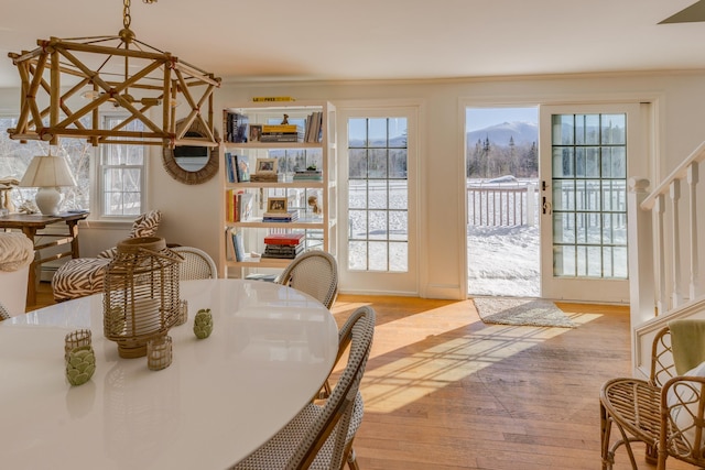 dining room with light wood-style floors and crown molding