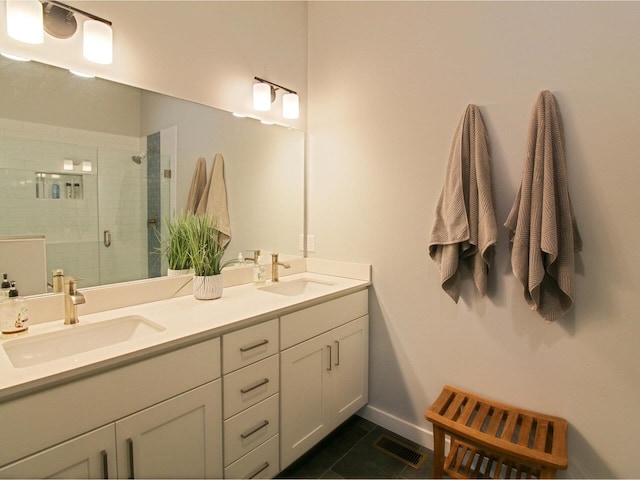 bathroom with double vanity, a stall shower, a sink, and visible vents