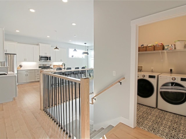 laundry room featuring laundry area, light wood-style floors, washer and dryer, and recessed lighting