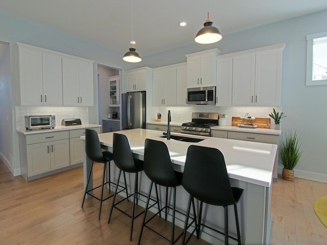 kitchen featuring appliances with stainless steel finishes, light countertops, and white cabinetry