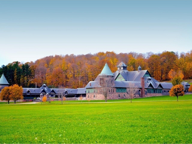 view of property's community featuring a view of trees and a lawn