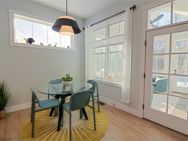 dining space with light wood-type flooring, baseboards, and visible vents