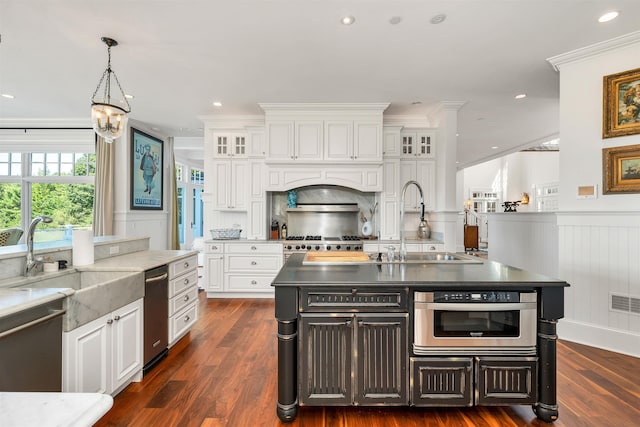 kitchen with an island with sink, a sink, glass insert cabinets, and white cabinets