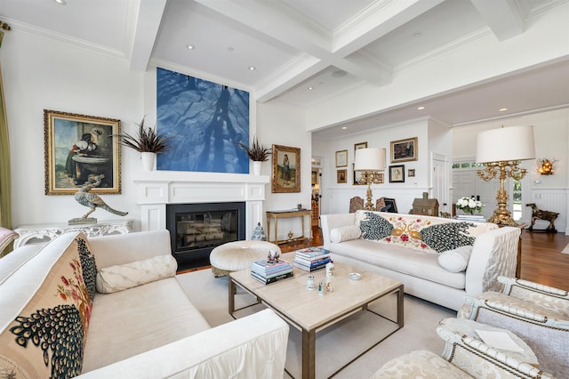 living area featuring light wood finished floors, a glass covered fireplace, and beam ceiling