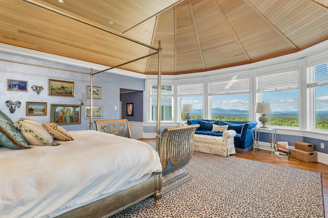 bedroom with wooden ceiling, multiple windows, high vaulted ceiling, and wood finished floors