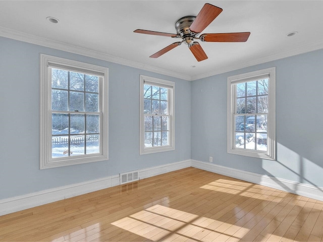 unfurnished room with light wood-style floors, visible vents, and a healthy amount of sunlight