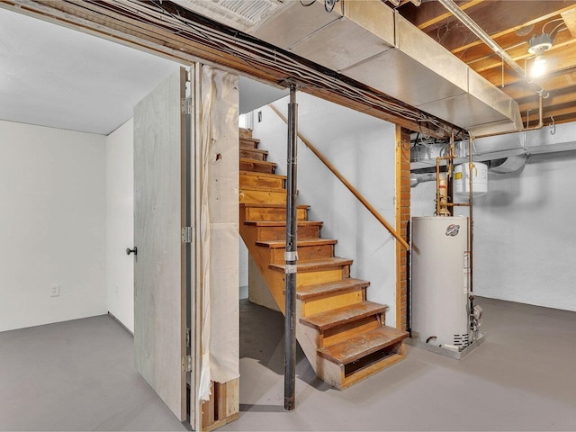 unfinished basement featuring stairway and gas water heater