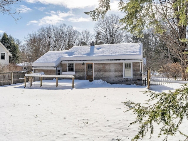 snow covered house with fence