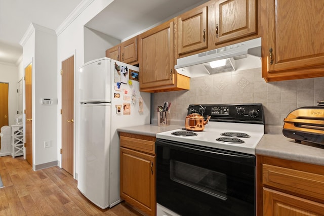 kitchen with range with electric stovetop, light countertops, decorative backsplash, freestanding refrigerator, and under cabinet range hood