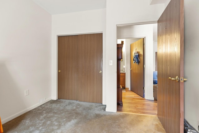 unfurnished bedroom with a closet and light colored carpet