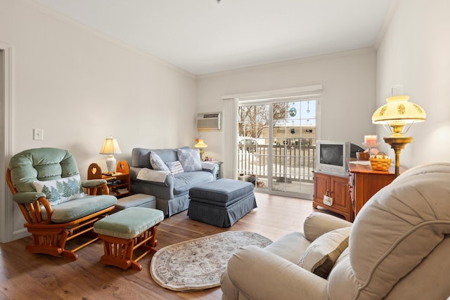 living area featuring baseboards, a wall mounted AC, light wood-type flooring, and crown molding