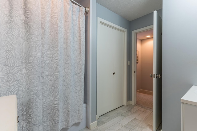 bathroom featuring shower / bath combo with shower curtain, a textured ceiling, vanity, and wood finished floors